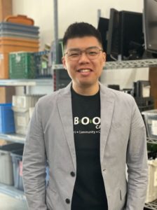 Hsing-Lei (Steve) Lee stands in front of shelving at reBOOT Canada's Vancouver location