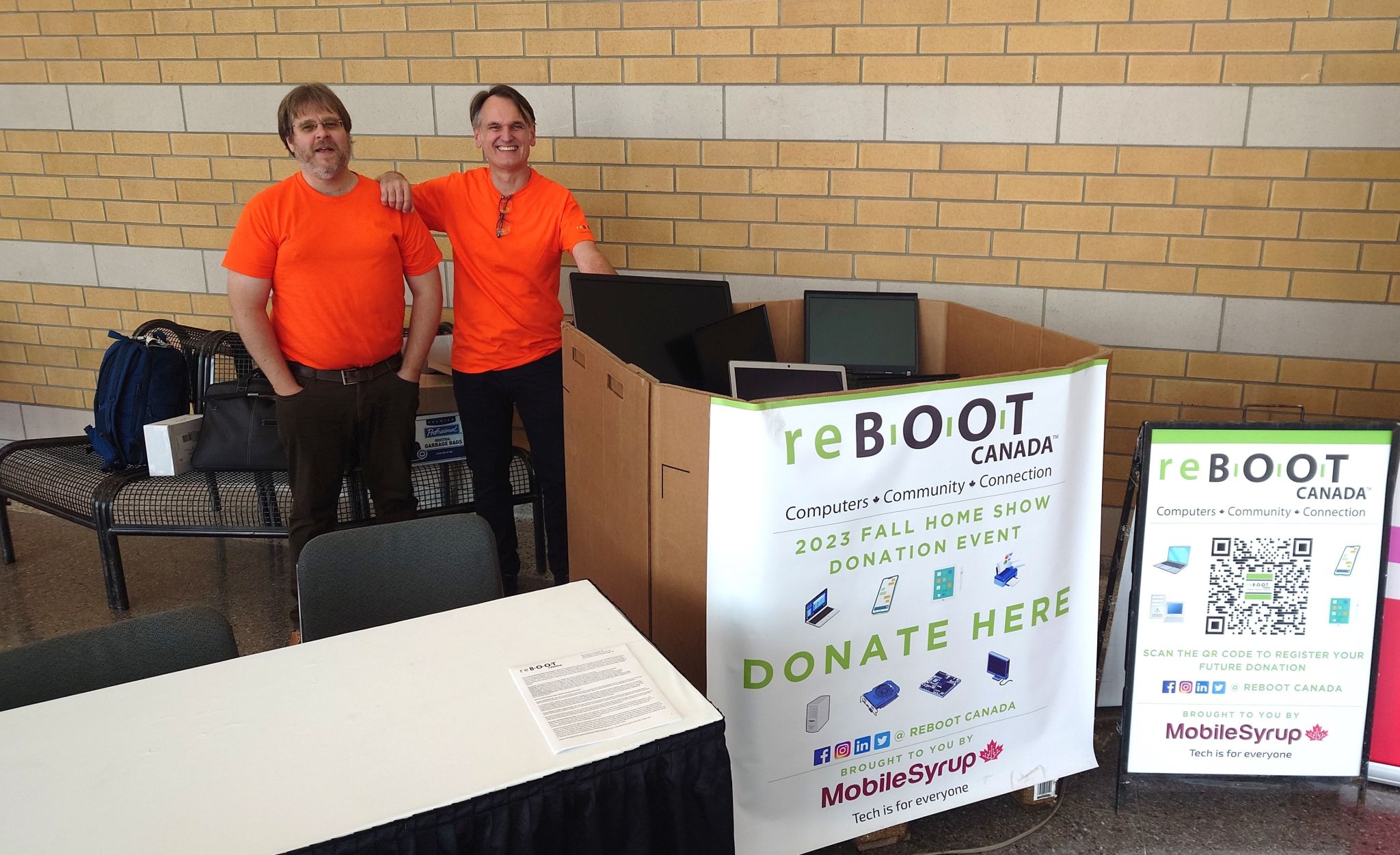 Lars Verholt and Franc Rota pose at the reBOOT Canada x MobileSyrup equipment donation station at Toronto's 2023 Fall Home Show.