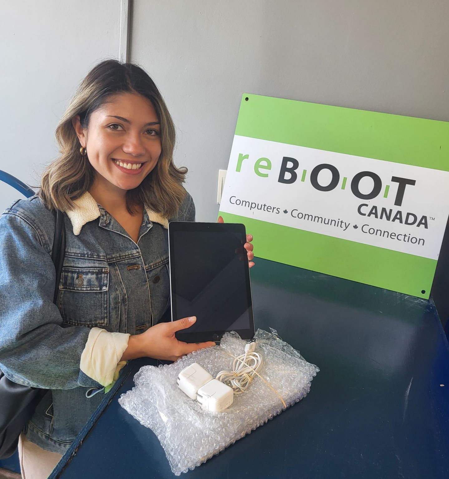 Representative of the 27th Reel Asian Film Festival poses with one of the iPads donated by reBOOT Canada. 
